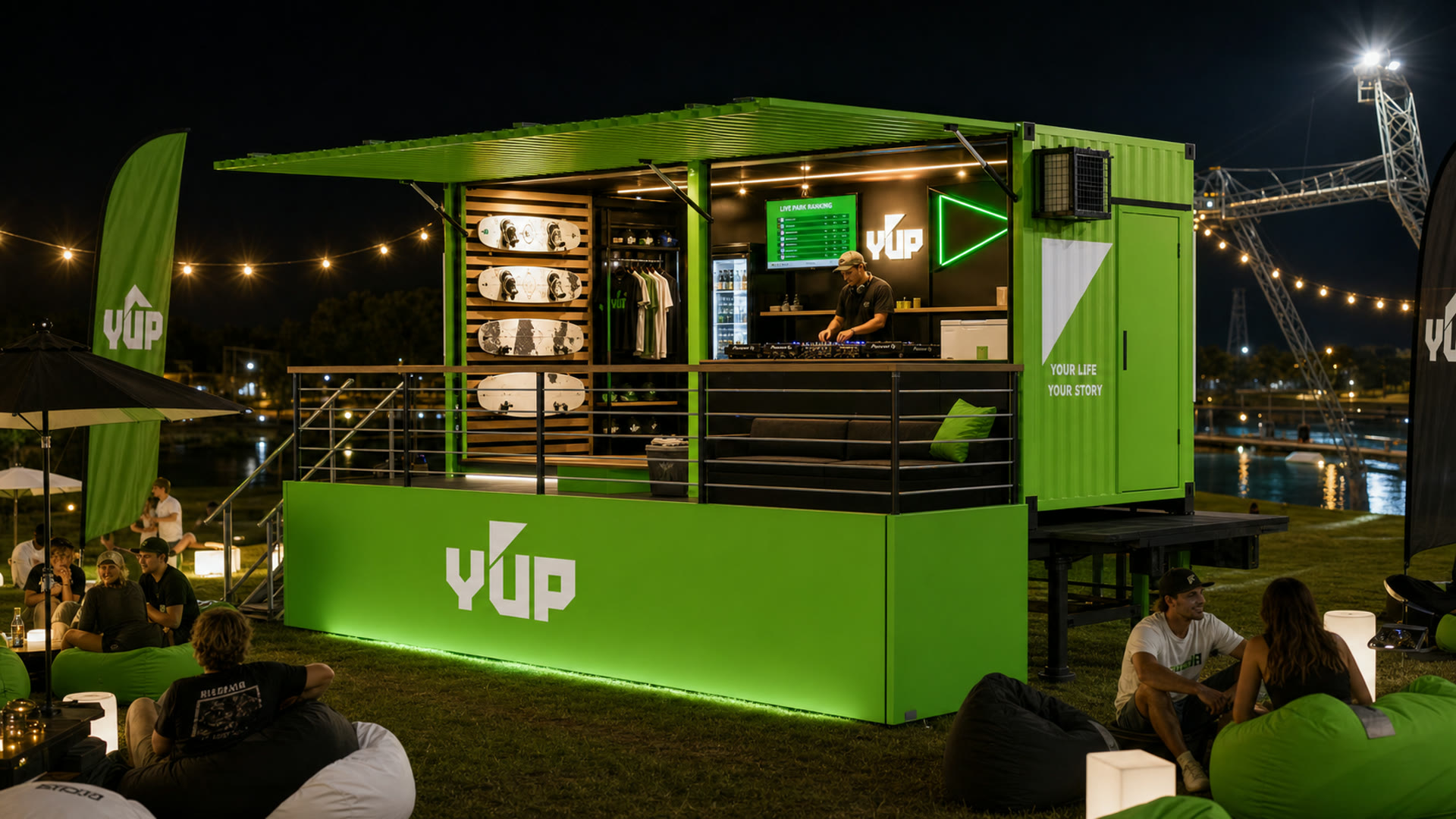 Brandtruck da Y'UP à noite, com DJ tocando, lounge iluminado e público em volta